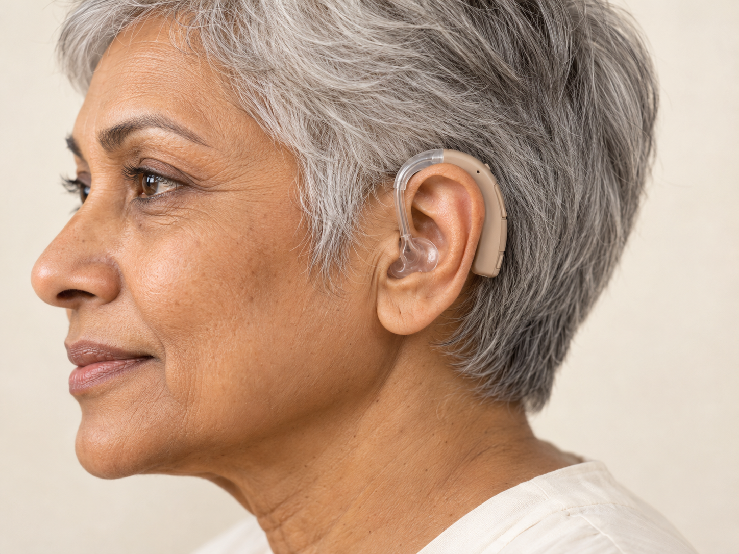 Behind-the-Ear (BTE) hearing aid fitted on a woman's left ear