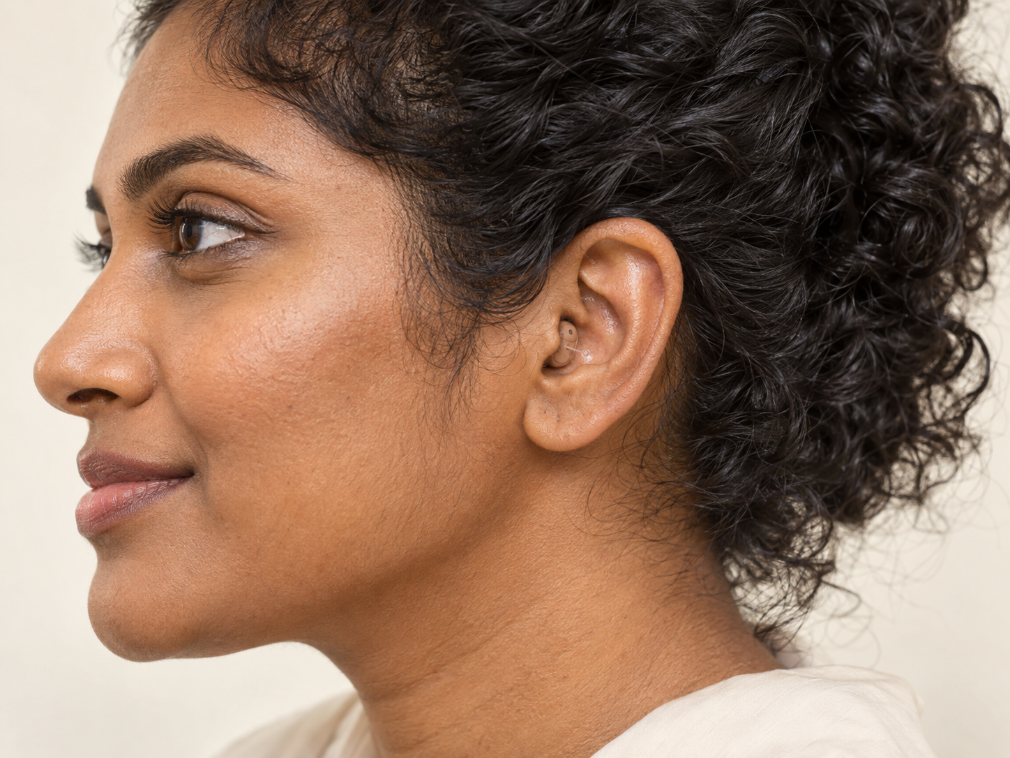 Completely-in-Canal (CIC) invisible hearing aid seated in a woman's left ear canal