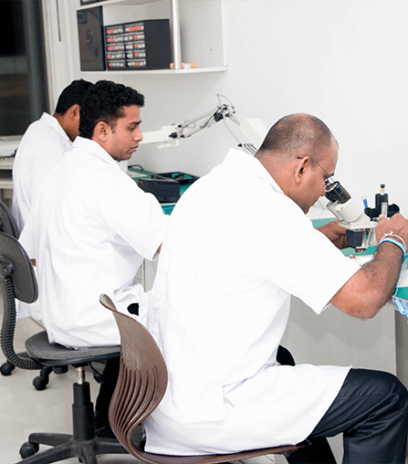 Team of hearing aid repair technicians working in certified cleanroom coats at Wickramarachchi Hearing Care